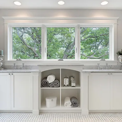 Three casement windows are installed over the dual sinks in this bathroom