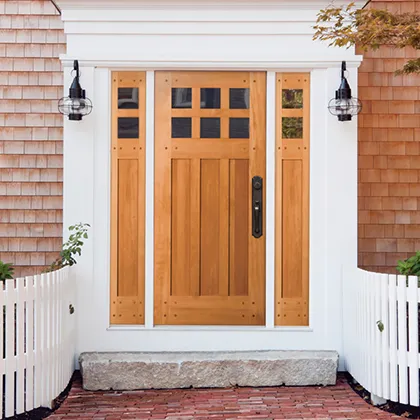 Simpson wood entry door with divided lites and matching sidelites for a Craftsman style entryway in this Cedar shingled home
