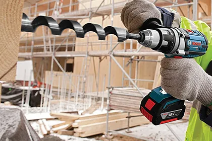 Workman drills into 4x8 with Bosch cordless drill