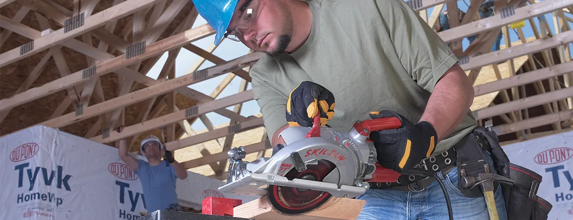 Contractor on job site uses a Skilsaw 15-amp 7-1/4 inch lightweight worm drive circular saw to cut a bevel