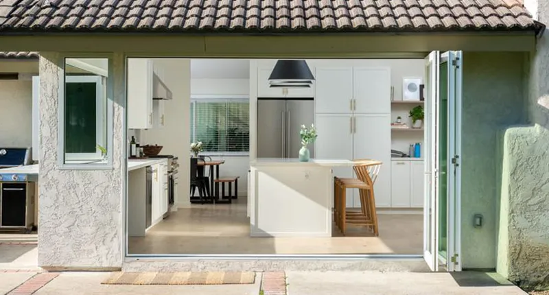 AG Millworks bi-fold doors open this kitchen to the backyard