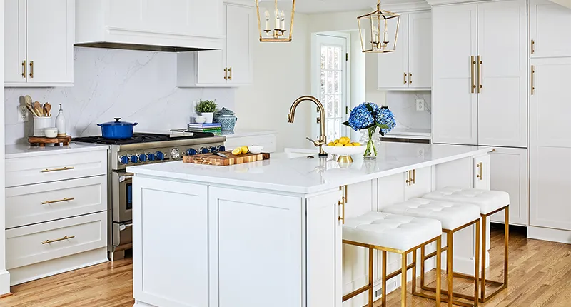 The clean look of this transitional style kitchen features Meadowland doors in Simply White with gold hardware and trim