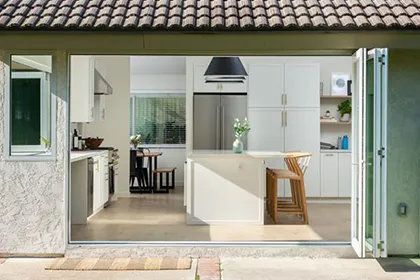 AG Millworks bi-fold doors open this kitchen to the backyard